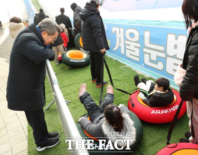 17일 개장한 경기도담뜰 겨울 눈밭 놀이터에서 김동연 지사가 썰매를 즐기는 아이들을 바라보고 있다. /경기도