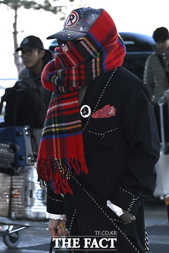 지드래곤이 목도리를 정리하고 있다.