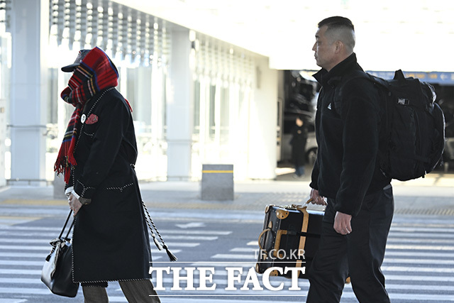 지드래곤이 목도리를 정리하고 있다.