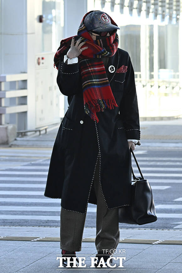 지드래곤이 목도리를 정리하고 있다.
