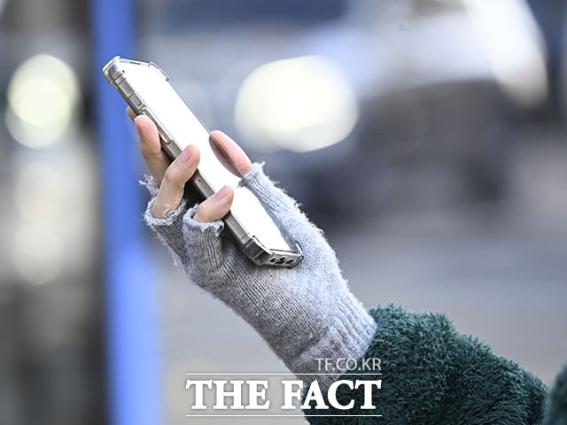 최근 북한의 공격 대상이 기업과 기관 내부 시스템을 넘어 개인 사용자의 모바일 환경까지 확대되고 있는 것으로 나타났다. 사진은 서울 종로구 광화문 인근 횡단보도에서 한 시민이 반장갑을 끼고 스마트폰을 들고 있는 모습. /송호영 기자