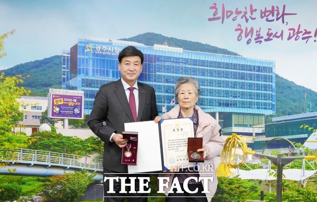 6·25전쟁 참전 고 최갑용 소위 유가족 최갑복씨(오른쪽)에게 화랑무공훈장 전수하는 방세환 광주시장(왼쪽). /광주시