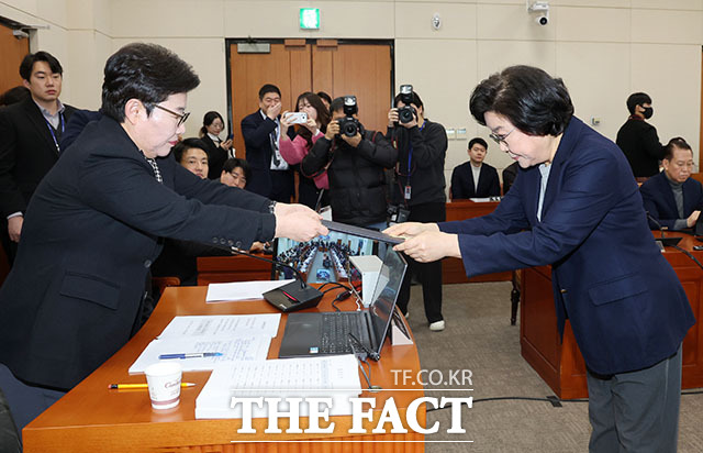 임이자 위원장(왼쪽)에게 선서문 전달한 뒤 인사 나누는 이 후보자.