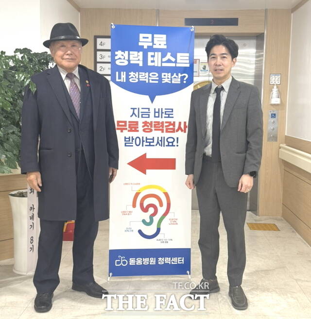 배영후 천안돋움병원 대표가 유흥준 천안시노인회장에게 배너 거치대에 게시된 진료서비스 내용을 설명하고 있다. /정효기 기자