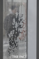  성에 낀 창 뒤로 걸어가는 시민 [포토]