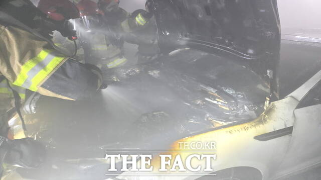 소방관들이 지하주차장 차량 화재 현장에서 보닛을 열고 옥내소화전을 활용해 진화하는 모습. /아산소방서