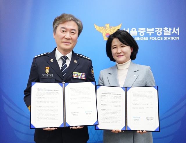 조운정 우리은행 중앙영업본부장(오른쪽)과 김산호 서울중부경찰서장이 피싱 범죄 예방 및 신속 대응을 위한 업무협약식에서 기념촬영을 하고 있다. /우리은행