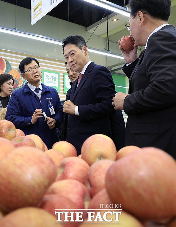 단식 종료 후 당무에 복귀한 장동혁 국민의힘 대표(가운데)가 28일 서울 서초구 하나로마트 양재점을 찾아 설 맞이 물가 점검에 나서 사과값을 살펴보고 있다. /남윤호 기자