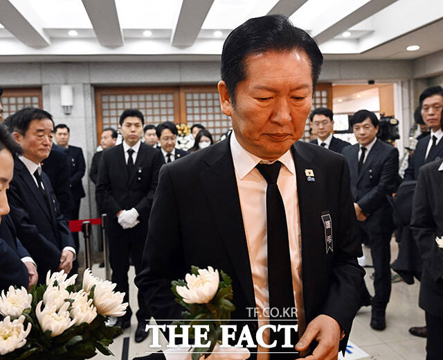 정청래 더불어민주당 대표가 국화꽃을 받아들고 있다.