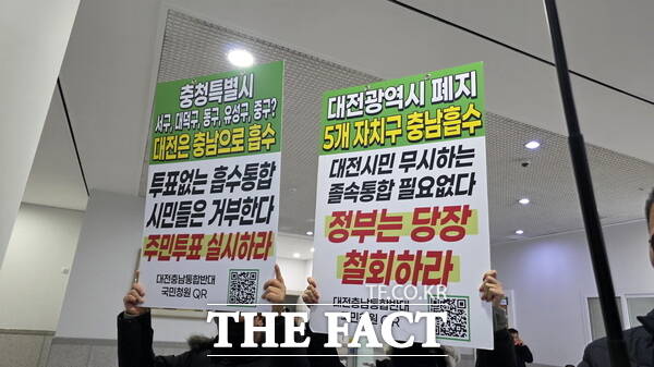 홍성현 충남도의회의장(왼쪽)과 조원휘 대전시의회의장(오른쪽)이 29일 대전시의회에서 공동 기자회견을 개최한 가운데 대전·충남 행정통합을 반대하는 시민들이 기자회견장에 피켓을 들고 시위를 하고 있다. /정예준 기자