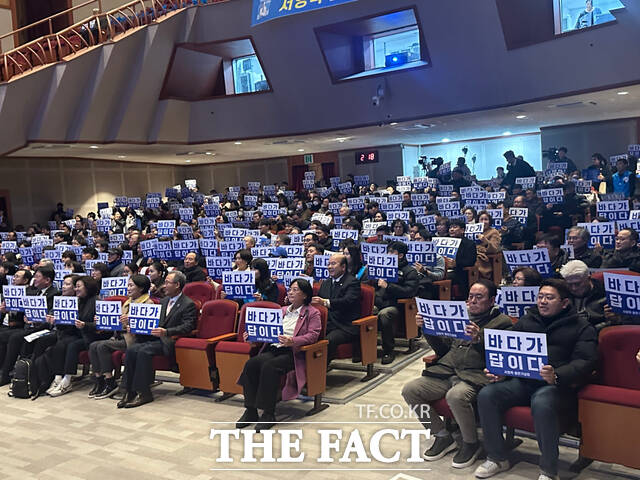 출판기념회에 참석한 시민들이 바다가 답이다 문구가 적힌 피켓을 들고 서영학 전 청와대 행정관의 메시지에 호응하고 있다. /고병채 기자