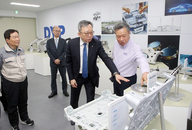 정상혁 신한은행장(앞줄 가운데)이 지난 1월 30일 경기도 화성시에 위치한 디와이피 화성 공장을 방문해 홍순겸 회장(앞줄 왼쪽)과 장인환 부사장(앞줄 오른쪽)으로부터 디와이피가 직접 생산한 부품에 대한 설명을 들었다. /신한은행