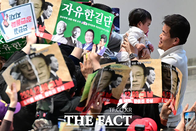 지난해 8월 한미 정상회담 일정에 맞춰 출국한 후 162일 만에 귀국한 전 씨가 한 지지자의 아이를 안아주고 있다.