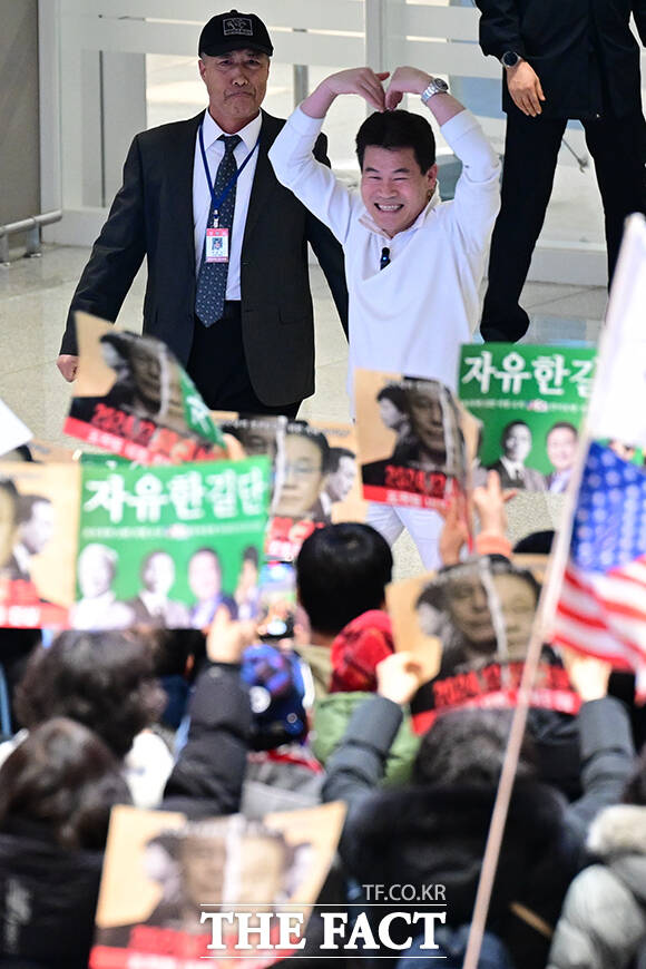 전 한국사 강사 전한길 씨(위)가 3일 인천국제공항 제2터미널로 귀국해 지지자들과 인사하고 있다. /인천국제공항=남윤호 기자