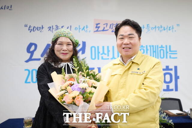 도고면 시민과의 대화에서 주민 대표가 25년 인연의 오세현 아산시장을 따뜻하게 맞이하며 꽃다발을 전달하고 있다. /정효기 기자