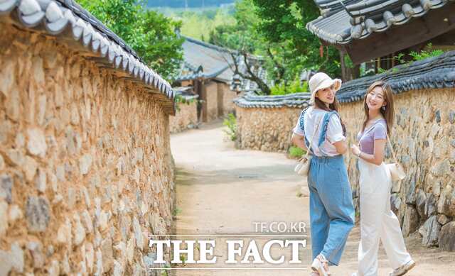 성주군 한개마을을 찾은 관광객이 돌담길을 걸으며 즐거운 표정을 짓고 있다. /성주군