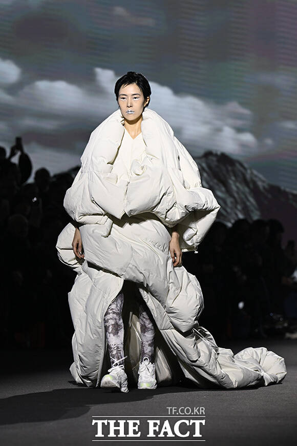 모델이 독창적인 디자인의 옷을 입은 채 런웨이를 걷고 있다.
