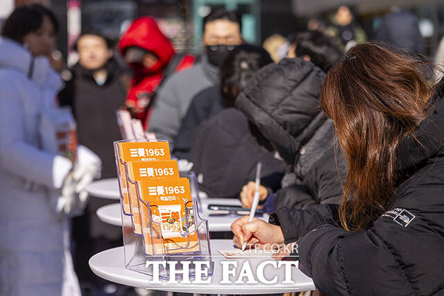 출시 100일 기념 메시지를 적는 참가자의 모습.