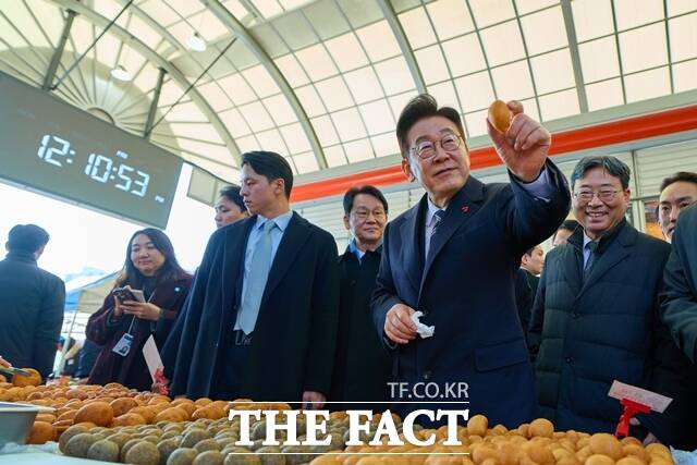 이재명 대통령은 9일 오후 종로구 통인시장을 깜짝 방문했다. 이 대통령이 1월 23일 울산 울주군 남창옹기종기시장을 방문해 도너츠를 집어들고 있다. /청와대