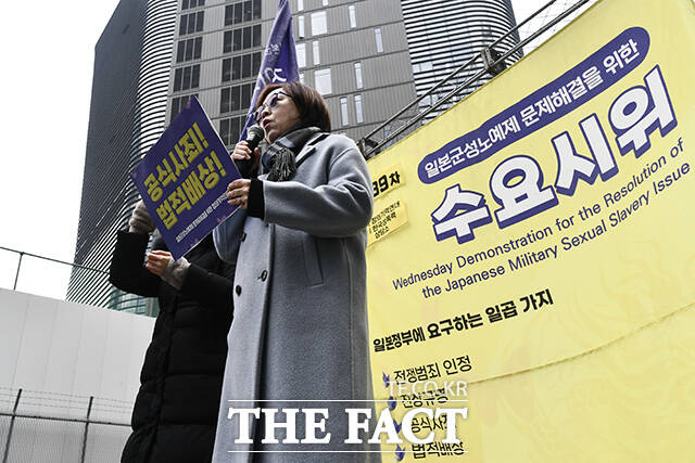 피켓을 든 수요시위 참가자가 연대발언을 하고 있다.