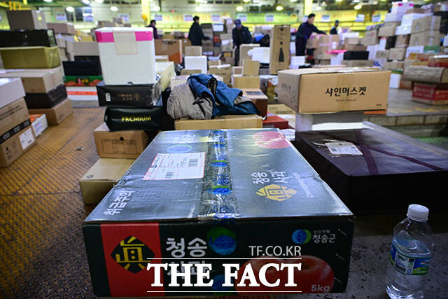 이른 새벽부터 시작된 택배 분류 작업에서 작업자들이 외투를 벗은 채 업무에 집중하고 있다.