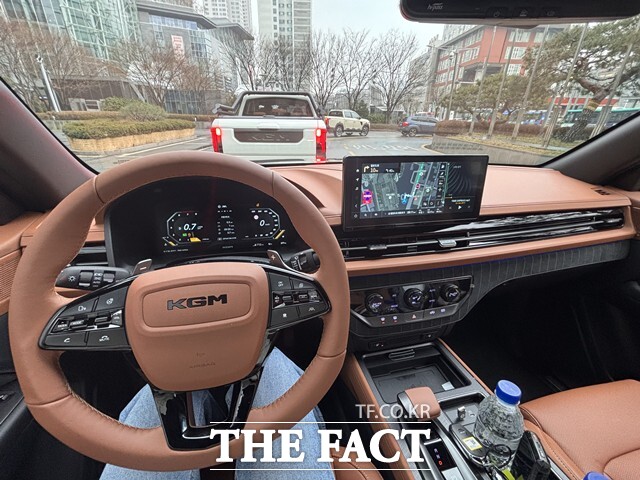 브라운 컬러 인테리어와 12.3인치 디지털 클러스터, KGM 링크 내비게이션이 적용된 무쏘 실내 모습. 가죽 마감 스티어링 휠과 전자식 변속 레버(SBW)가 적용됐다. /황지향 기자