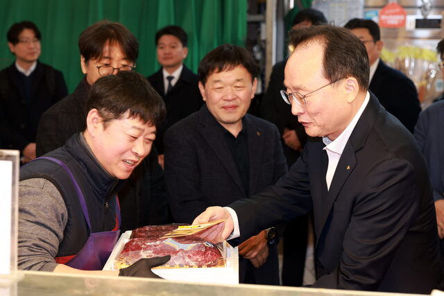 11일 망원시장에서 열린 2026 설맞이 전통시장 사랑나눔 행사에서 이환주 KB국민은행장이 식료품을 구입하고 있다. /KB국민은행