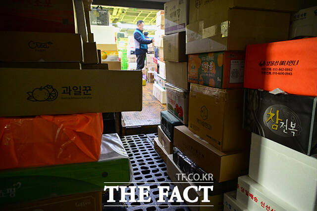 이른 새벽부터 시작된 택배 분류 작업에서 작업자들이 외투를 벗은 채 업무에 집중하고 있다.