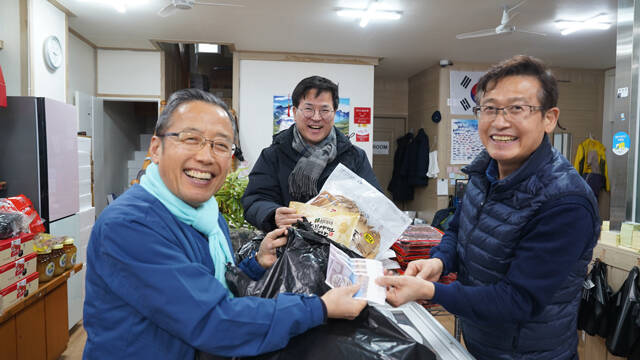 김외철 국립울진해양과학관장(왼쪽)이 온누리상품권을 활용해 설 제수용품 등을 직접 구매하고 있다. /국립울진해양과학관