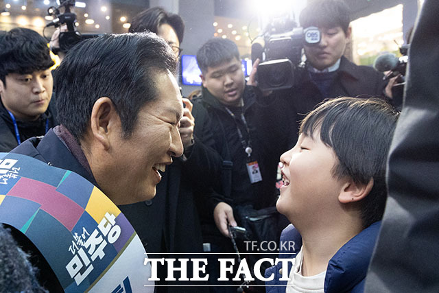 정청래 더불어민주당 대표(왼쪽)가 13일 오전 서울 용산구 용산역에서 설 귀성객 인사를 하며 아이와 눈을 맞추고 있다. /남용희 기자