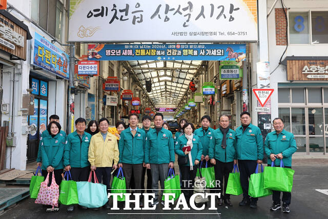 예천군의회가 소속 의원과 사무국 직원들이 함께 예천읍 전통시장을 찾아 설맞이 전통시장 장보기 행사를 진행한 후 단체 기념사진을 찍고 있다. /예천군의회