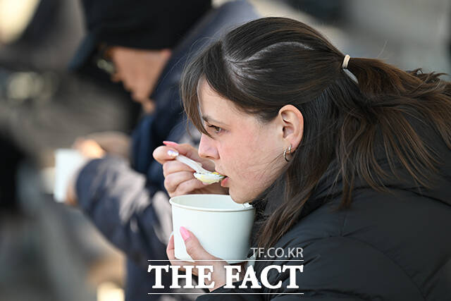 한국의 떡국 맛보는 외국인의 모습.