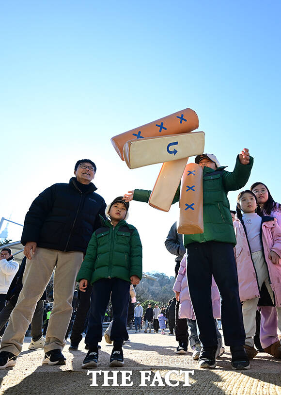 남산골 설축제를 찾은 한 가족이 윷을 던지고 있다.
