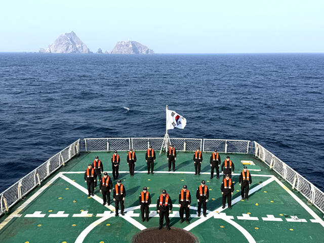 동해해경 5001함 직원들이 설 명절 연휴 독도 인근 해상에서 경비 임무를 수행 중 함상에서 새해 결의를 다지고 있다. 뒤로는 독도가 보이고 있다. /동해해경