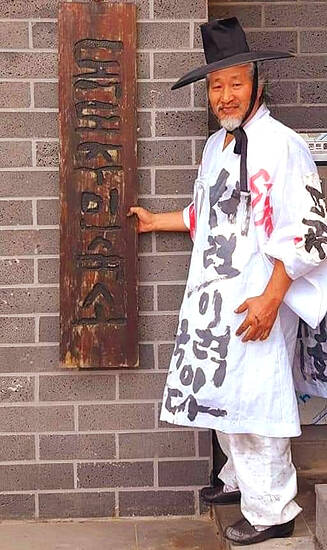 김동욱 서예가가 독도주민숙소 준공 당시 현판을 제작해 설치한후 기념사진을 찍고있다. /쌍산 김동욱 서예가