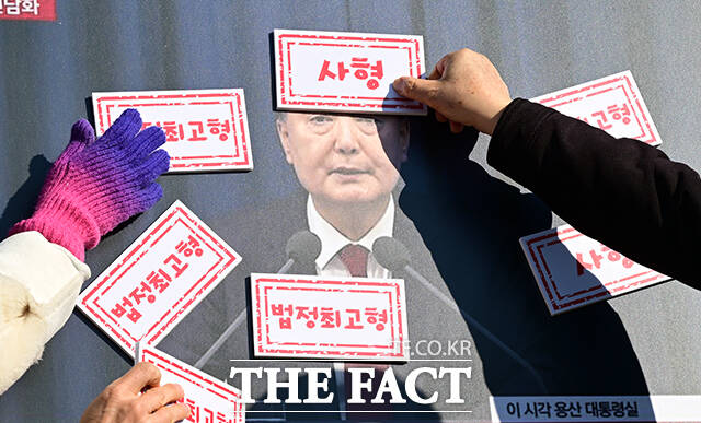 윤석열 법정 최고형 촉구 기자회견이 19일 오전 서울 종로구 광화문 월대 앞에서 열린 가운데 참가자들이 윤석열 사진에 사형 선고 도장을 부착하고 있다. /임영무 기자