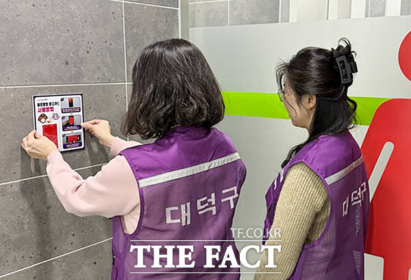 대전 대덕구 관계자와 주민참여단이 19일 공공화장실에 불법촬영 탐지카드를 설치하고 있다. /대덕구