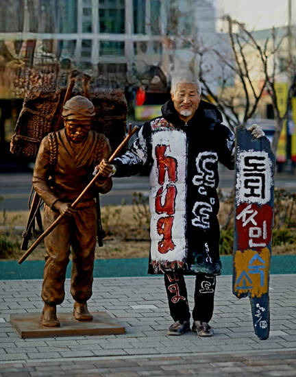 김동욱 서예가가 포항시 동빈로 항 조형물 앞에서 독도 주민숙소 현판 퍼포먼스 행사를 열고 있다. /쌍산 김동욱 서예가