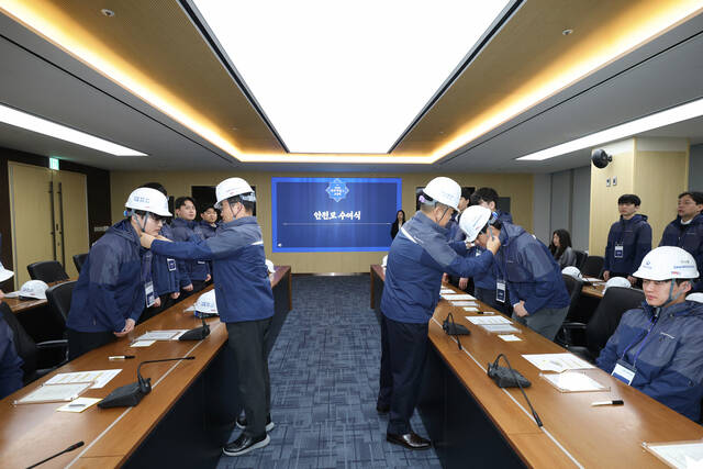 김보현 대우건설 대표이사(왼쪽)와 심상철 노동조합 위원장(오른쪽)이 신입사원에게 안전모를 씌워주고 있다. /대우건설