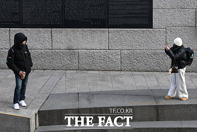 서울 아침기온이 0도를 기록한 20일 오전 서울 중구 청계천에서 관광객들이 두꺼운 옷을 입은 채 기념촬영 하고 있다.