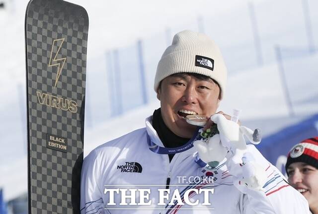 스노보드 은메달리스트 김상겸이 지난 8일(현지 시간) 이탈리아 리비뇨 스노우파크에서 열린 2026 밀라노코르티나 담페초 동계올림픽 스노보드 남자 평행대회전 메달 시상식에서 은메달을 입에 물고 있다. /리비뇨 뉴시스