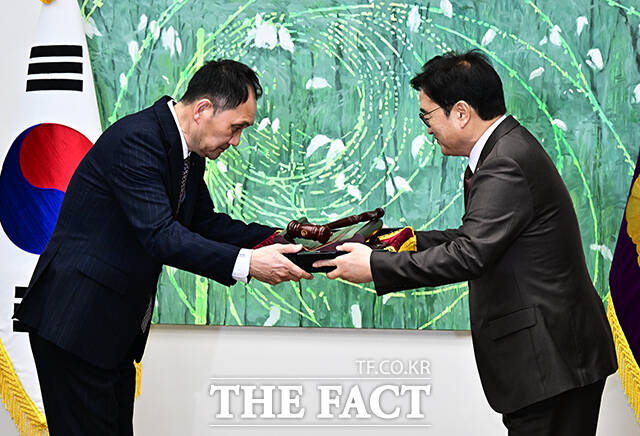 우원식 국회의장(오른쪽)이 25일 오전 서울 여의도 국회에서 열린 ‘국회기록원 제1호 기록물 기증식’에 참석해 본회의장에서 사용하던 의사봉과 의사봉판을 기증하고 있다. /국회=배정한 기자