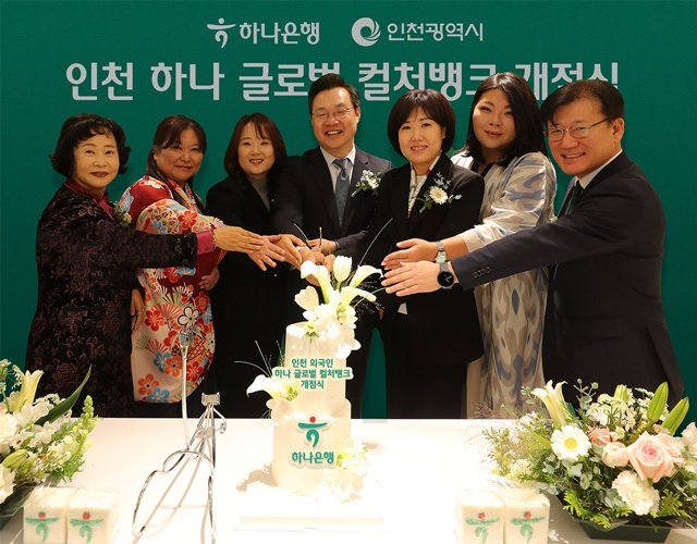 하나은행은 25일 인천 남동구 소재 남동산단금융센터지점 2층에 외국인 주민의 자립과 성장을 지원하기 위한 글로벌 커뮤니티센터 '인천 하나 글로벌 컬처뱅크'를 개점했다. 김미숙 하나은행 중앙영업그룹 부행장(오른쪽에서 세번째), 하병필 인천광역시 부시장(오른쪽에서 네번째) 및 행사에 참석한 관계자들이 축하 케이크를 자르며 기념촬영을 하고 있다. /하나은행
