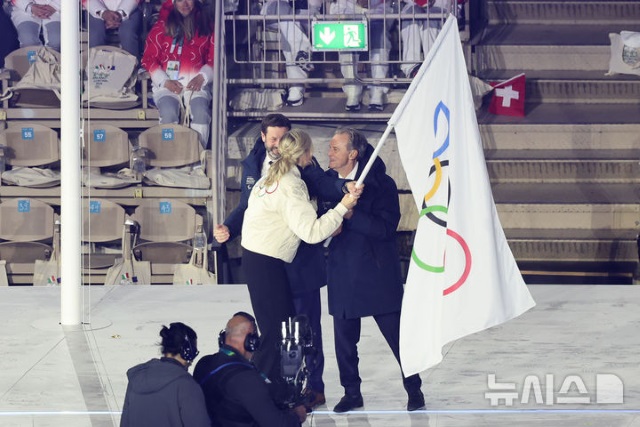 2026 밀라노·코르티나담페초 동계올림픽 폐회식에서 커스티 코번트리 국제올림픽위원회(IOC) 위원장이 2030년 동계 올림픽을 주최하는 프랑스 대표자에게 오륜기를 전달하고 있다. 어쩌면 다음 동계 올림픽부터는 눈과 얼음이 아니라 진흙길과 비포장도로를 달리는 새로운 종목을 보게 될지도 모른다. / 뉴시스