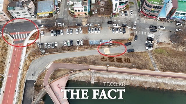 26일 전주시 덕진구 우아동1가 아중저수지(아중호수)로 향하는 폐쇄된 옛 진출입로(오른쪽 빨간색 원)와 우회도로(왼쪽 빨간색 원)를 <더팩트>가 드론 장비로 촬영한 현장 모습. 현재 해당 도로 폐쇄와 관련해 전주시는 신설한 우회도로 노면 표시 등의 기본적인 안내조차 하지 않고 있다. /전주=김수홍 기자