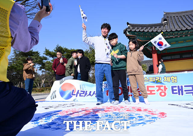107주년 3.1절을 하루 앞둔 28일 오후 충남 천안시 동남구 유관순 열사 사적지 일대에서 2026 아우내봉화제가 열린 가운데, 행사를 찾은 어린이 가족들이 대형 태극기 만들기에 참여한 뒤 만세를 외치고 있다. /천안=이새롬 기자