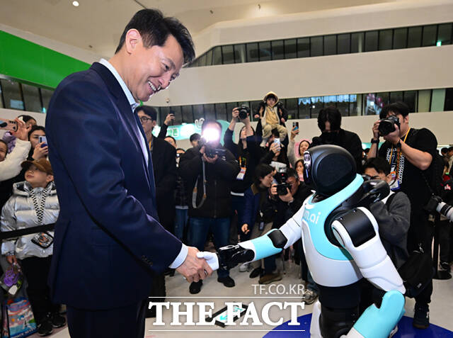 오세훈 서울시장이 1일 서울 동대문디자인플라자(DDP)에서 열린 '서울AI페스티벌 2026'에 참석해 마음ai의 완전 자율형 민첩 로봇 '우치봇'과 악수하고 있다.