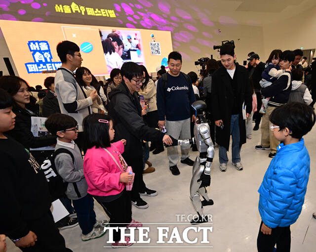 1일 서울 동대문디자인플라자(DDP)에서 열린 '서울AI페스티벌 2026'에 참가한 어린이들이 휴머노이드 로봇 G1과 손인사를 하고 있다.