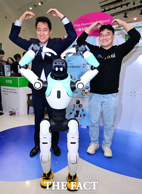 오세훈 서울시장이 1일 서울 동대문디자인플라자(DDP)에서 열린 '서울AI페스티벌 2026'에 참석해 마음ai의 완전 자율형 민첩 로봇 '우치봇'과 악수하고 있다.