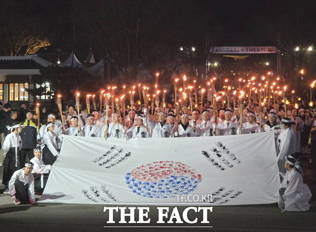 28일 천안아우내장터에서 열린 2026 아우내봉화제에서 시민들이 대형태극기와 함께 횃불을 들고 행진을 준비하고 있다. /정효기 기자